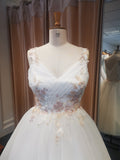 Close up of delicate pleated bodice tulle bridal gown with coloured floral embroidery.