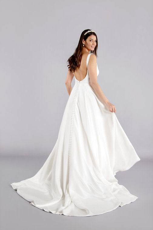 Back of full length pure simplicity crepe bridal gown with train and skirt pockets