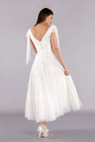 Back of soft tulle tea length wedding dress featuring V-neck and soft boho full skirt.