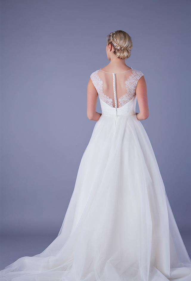 Back of Tea length wedding dress with plunge lace illusion bodice and tulle skirt with pearl and bead waist detailing.