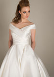Deluxe Mikado wedding gown with dress with beautifully pleated bodice, wide neck line and full Mikado skirt with pockets completes this classic gown. Just beautiful!  Also available in shorter tea and Fifties lengths.