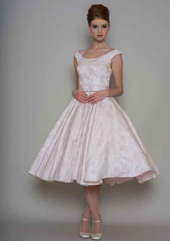  Cute brocade Fifties inspired tea length wedding dress with bow belt and button back bodice shown here in Ivory.. 