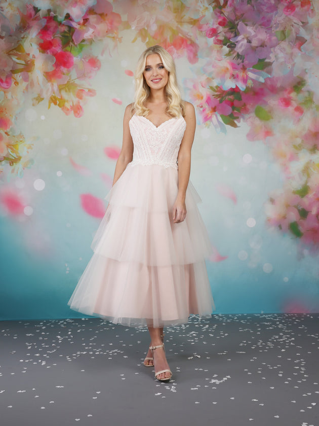 Pretty mid calf length blush wedding dress with sweetheart shaped bodice and delicate lace applique decorated with flowers and leaves.   em-iyla
