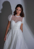 The bodice of the Adelaide contemporary lace and tulle wedding dress with high neck and small puff sleeves.