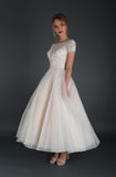 Side of tea length bridal gown with embellished bodice and cap sleeve.