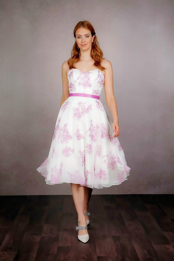 A pretty strapless satin tea-length dress in shorter 50's style length, with a delicately embroidered chiffon overlay. Finished with a smooth satin waistband and covered buttons.  rd-grace